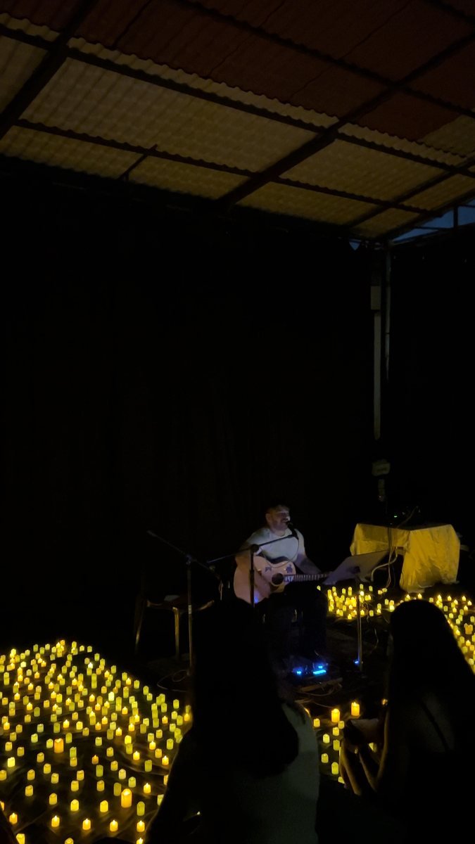 The audience watching from among the candles.