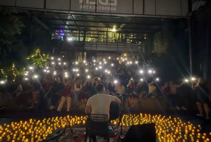 An audience watching live music by candlelight.