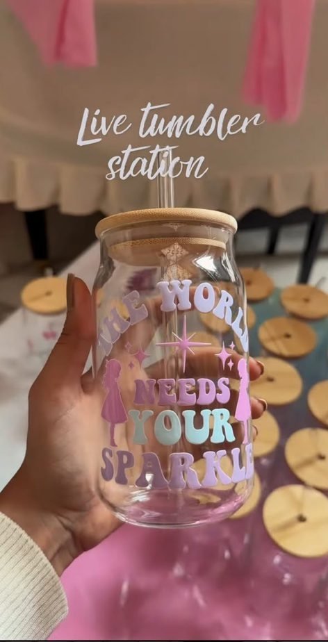 A glass tumbler decorated with lettering, held up at the station.
